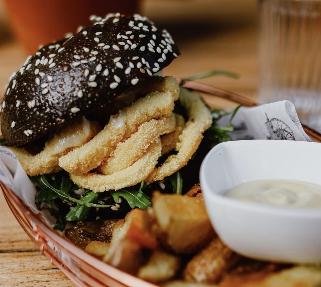Crispy fries and a gourmet burger served on a red‑and‑white ceramic plate in Brunswick, Melbourne.