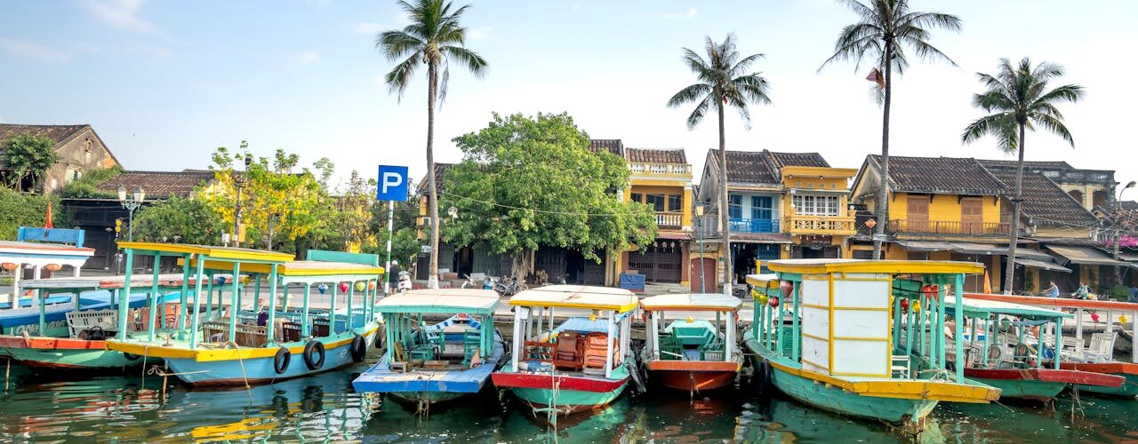 Hội An, Vietnam – Cruise boats moored on river in tropical village