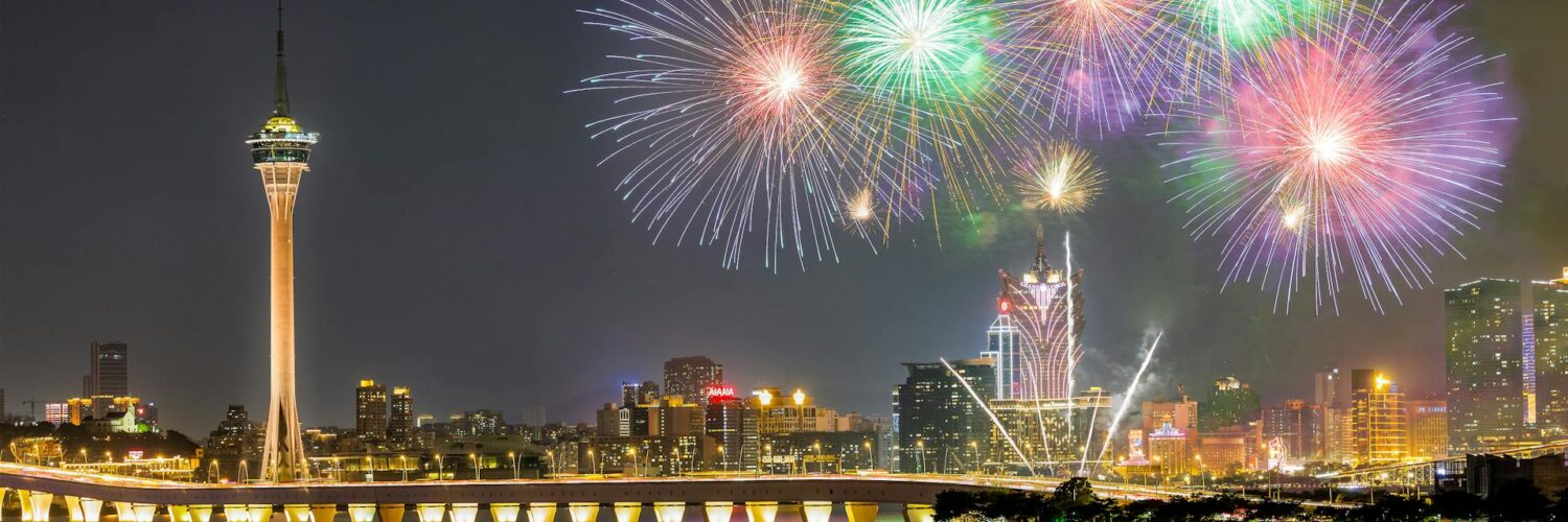 Colorful fireworks lighting up the Macau skyline at night.