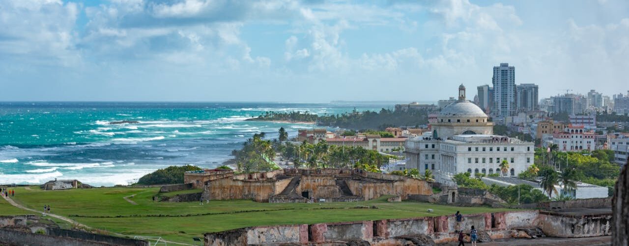 Colonial buildings, domes, and the iconic El Morro fortress, all perched along a rugged shoreline.