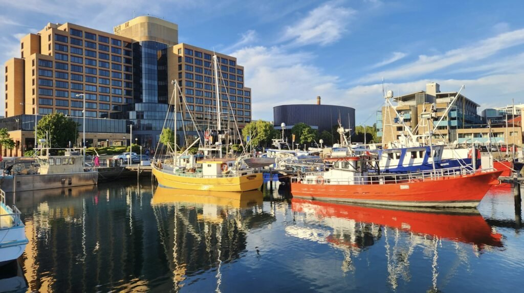 Boats docked along the Hobart waterfront in front of historic buildings on a clear day in Tasmania.