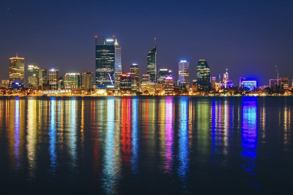 Aerial night view of Perth city skyline with illuminated high‑rise buildings
